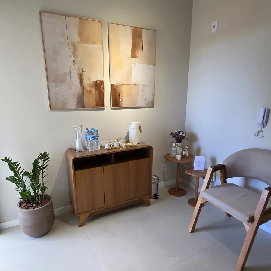 Recepção da clínica, com poltronas e aparador de madeira